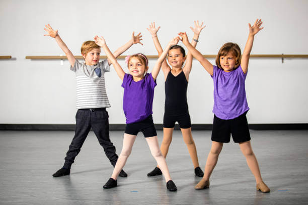 A cute group of children practicing musical theater in a dance studio